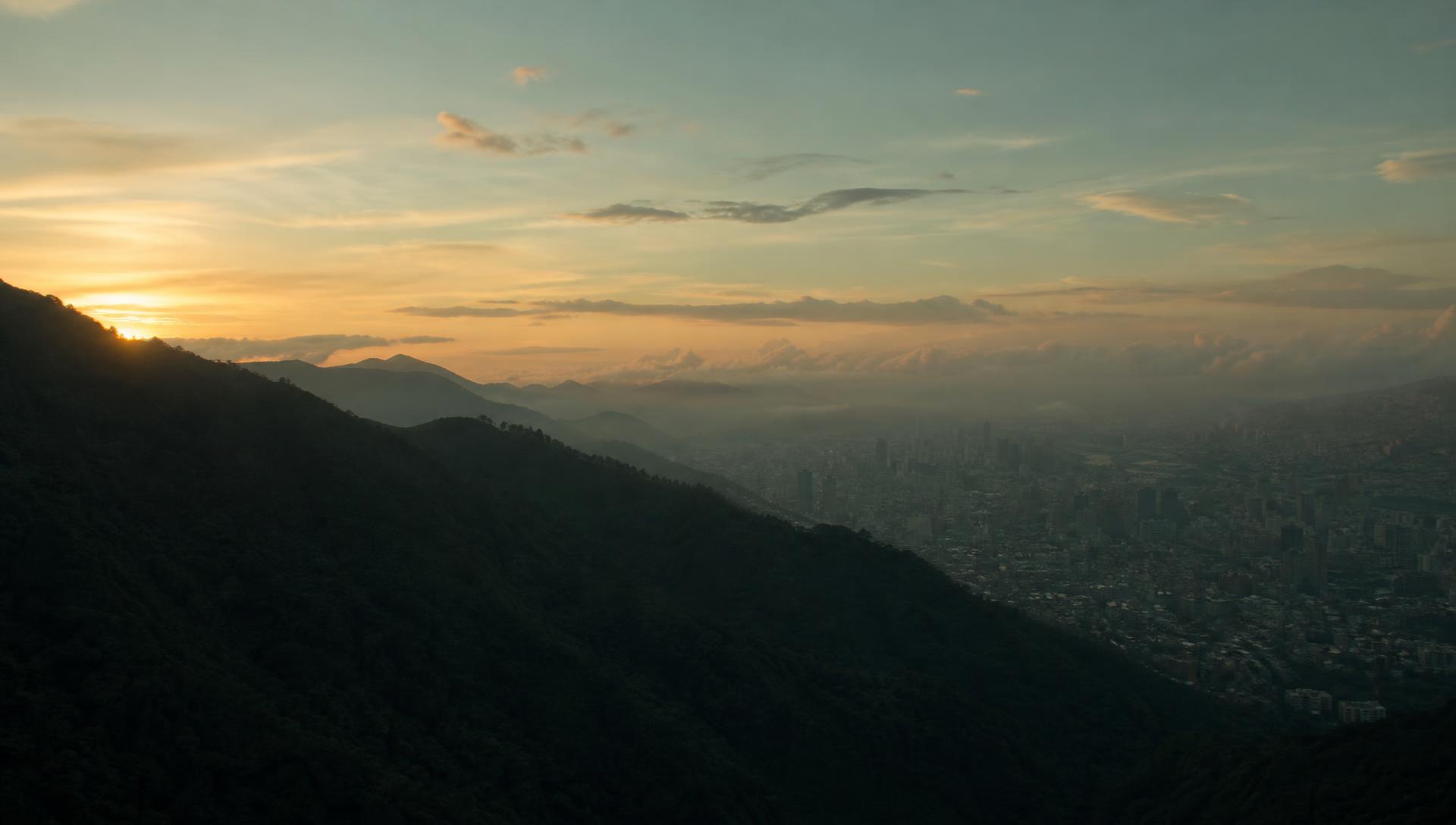 The Ávila mountain range at early sunrise with the Caracas skyline behind it